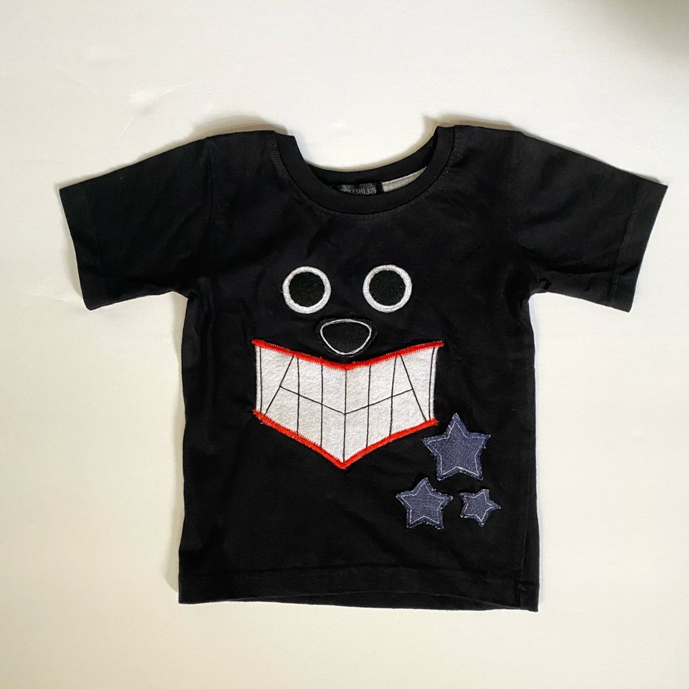 French Toast Black Tee with Embroidered Smile & Blue Star Appliqués